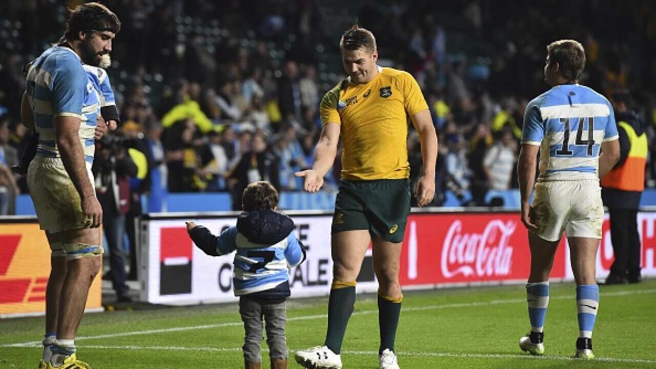 Australia's wing Drew Mitchell (C) shakes hands with a boy next to Argentina's flanker Juan Martin Fernandez Lobbe (L) after a winning during a semi-final match. AFP PHOTO / GABRIEL BOUYS