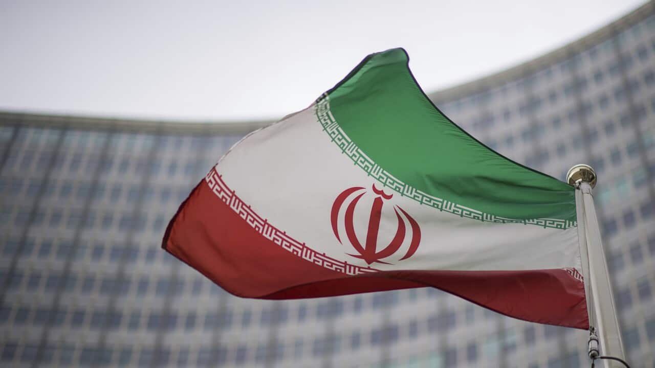 A national flag of Iran waves in front of the building of the International Atomic Energy Agency