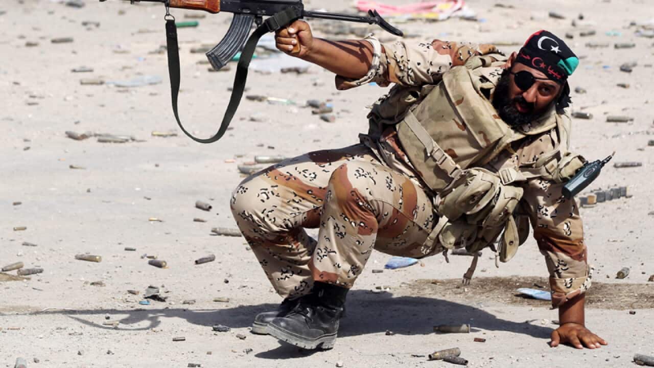 A Libyan rebel fighter fire his weapon