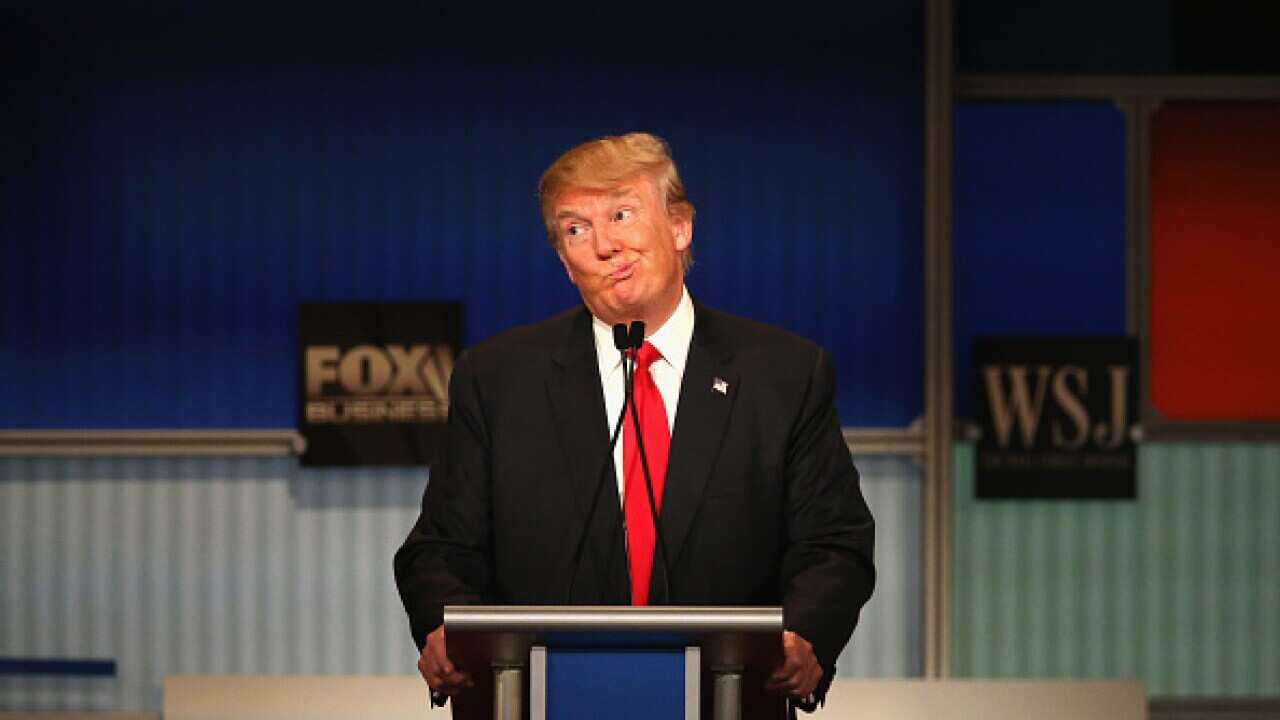 Presidential candidate Donald Trump gestures after Carly Fiorina says she met with Russian President Putin at a one on one meeting, during the Republican Presidential Debate sponsored by Fox Business and the Wall Street Journal at the Milwaukee Theatre No