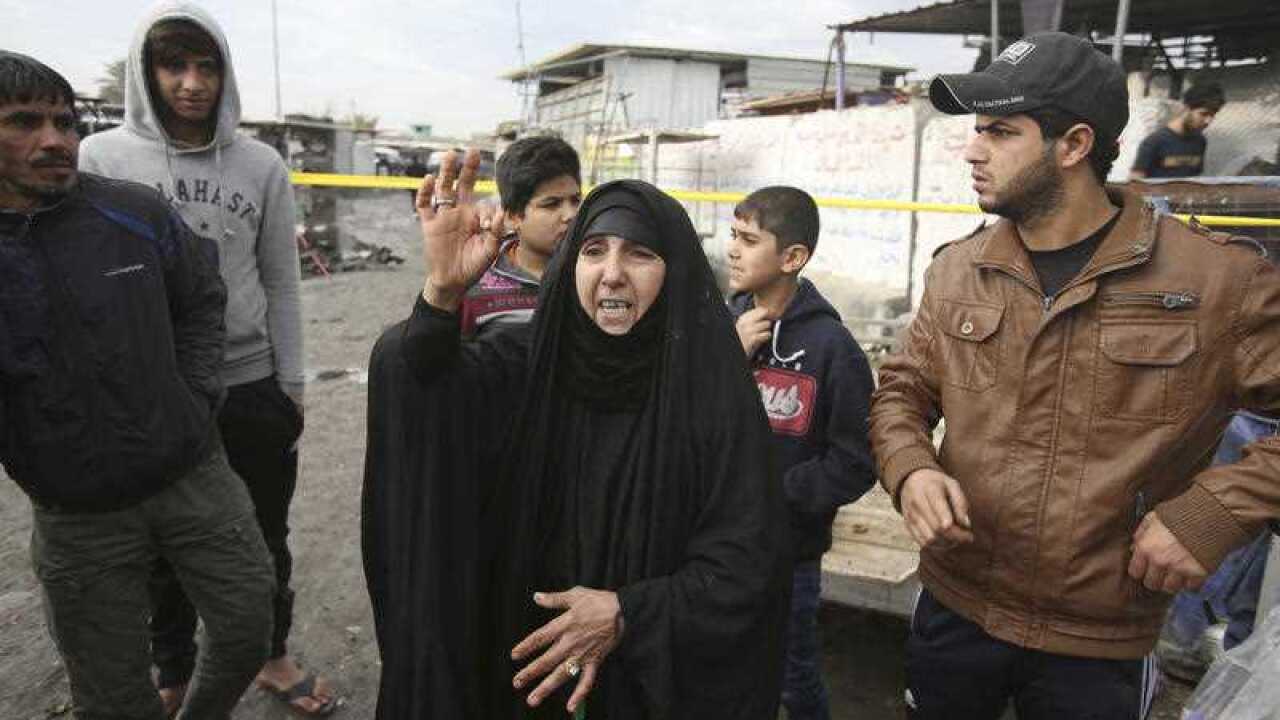 An Iraqi woman looks at damages from a car bomb explosion at a crowded outdoor market in the Iraqi capital's eastern district of Sadr City, Iraq, Monday, Jan 2