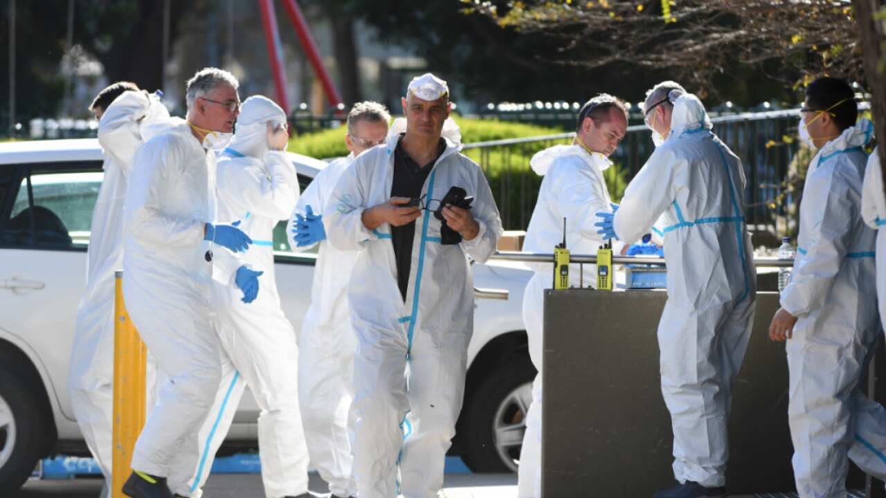 People wearing personal protective equipment are seen after entering a public housing tower in Flemington, Melbourne, Thursday, July 9, 2020