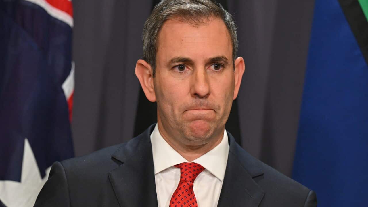 Man in suit grimaces.