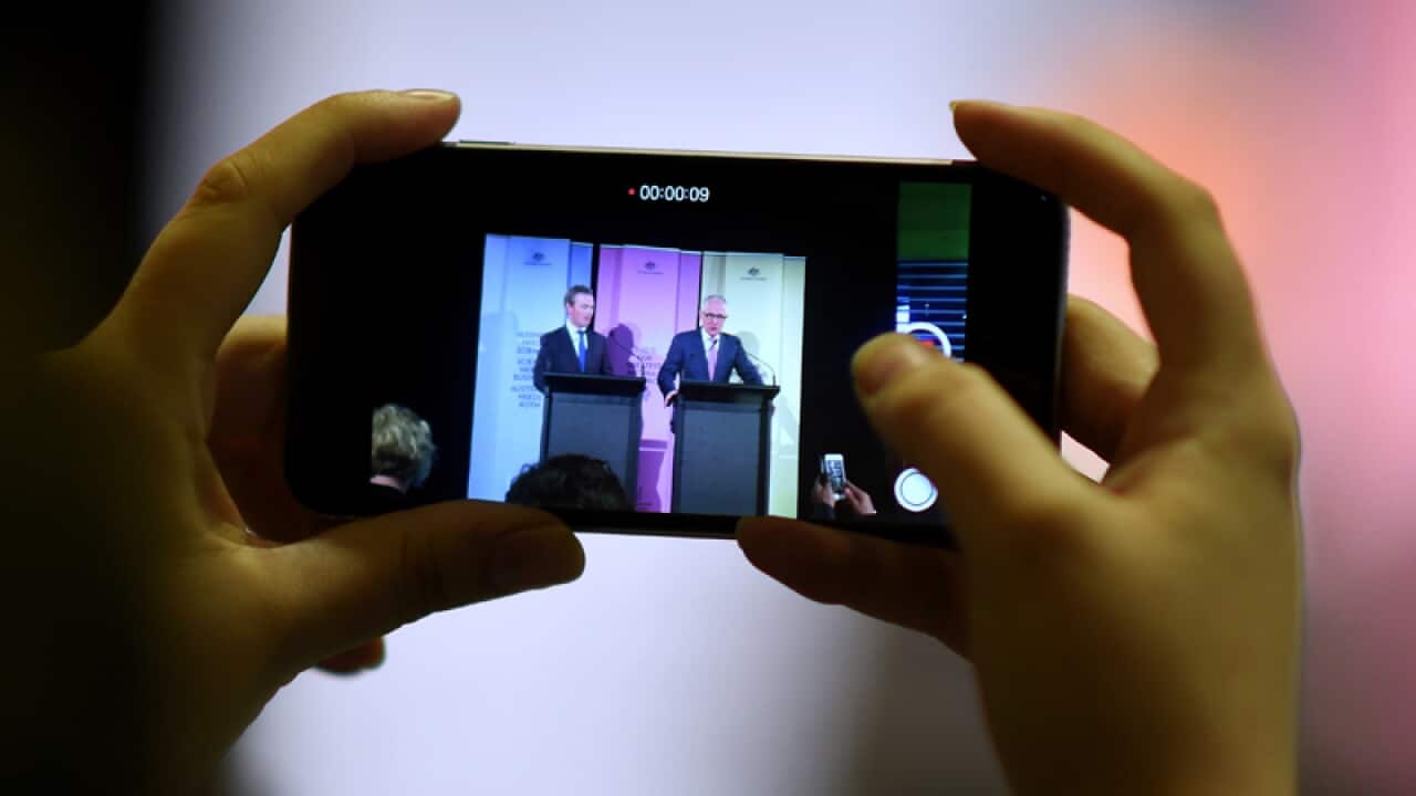 A journalist films Australian Prime Minister