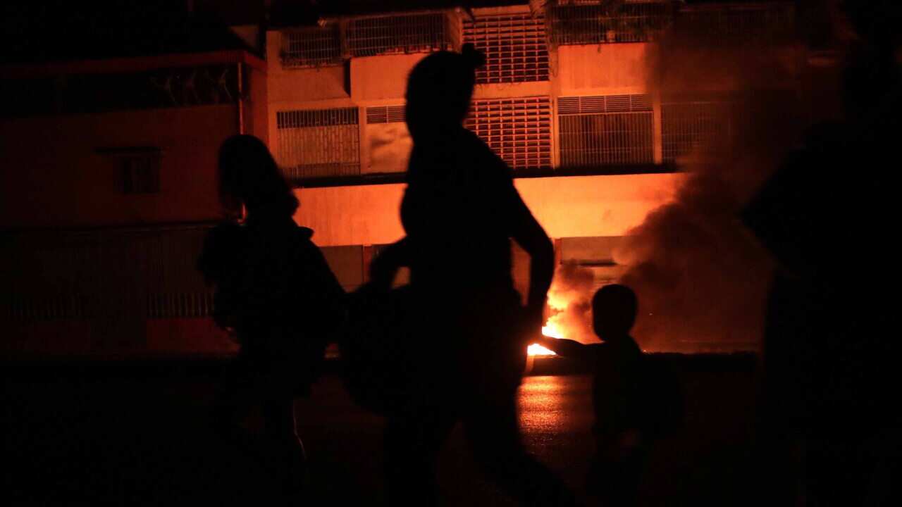 People walk in a street in the dark during a power outage in Caracas, Venezuela.
