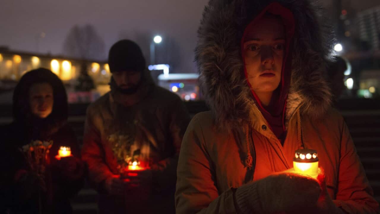 People light candles in memory of victims of a military plane crash