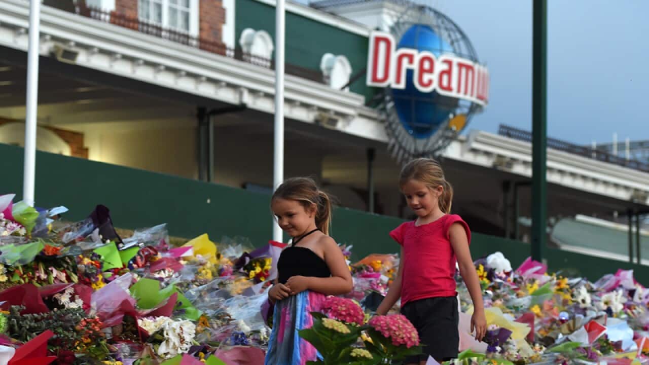 Children walk among tributes outside the Dreamworld theme park