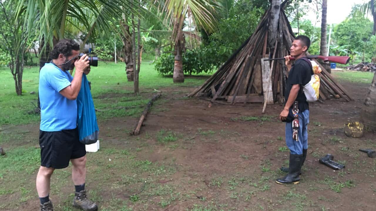 Photographer Carlos Villalon photographs a local while on the way to the Darién.