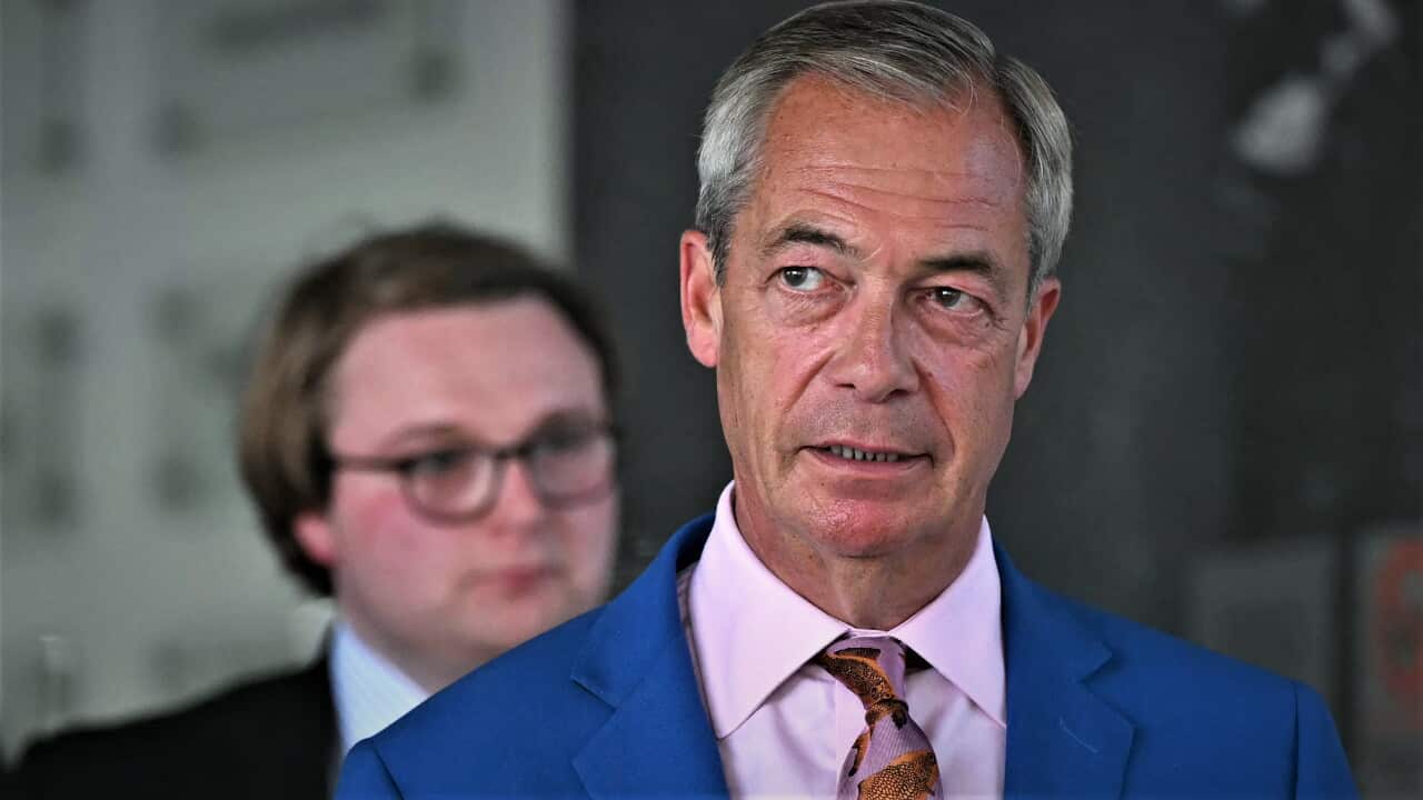 Nigel Farage in a blue suit with a neutral expression.