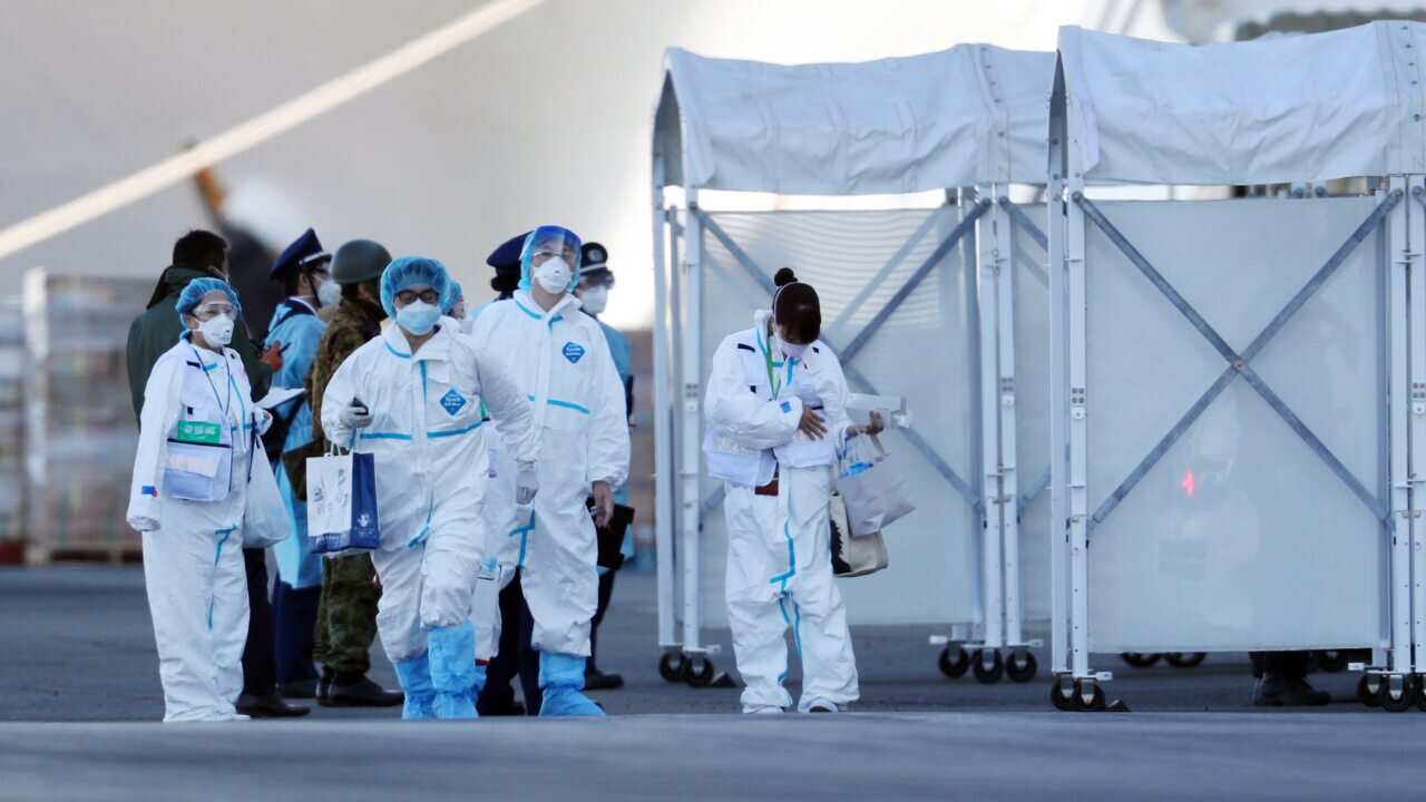 Staff members wearing protective gear prepare to enter the Diamond Princess cruise ship docked in Yokohama, Japan, 10 February 2020.