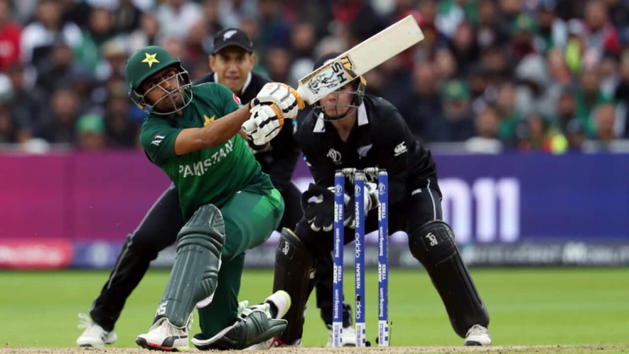 Pakistan's batsman Babar Azam, front, watches his shot as New Zealand's wicketkeeper Tom Latham, right, with teammate Ross Taylor