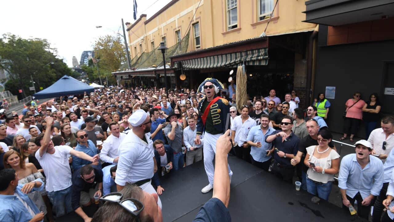 A large crowd enjoy a two up game being played