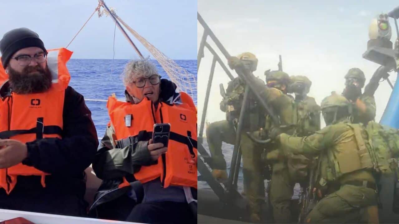 On the left, two civilians—a bearded man wearing glasses and a black beanie, and an older person with short grey hair and glasses holding a smartphone—sit on a boat in calm blue waters. Both are wearing bulky, bright orange life jackets and looking toward the right.
On the right, a group of military or tactical personnel in full green camouflage, helmets, and tactical gear are boarding a vessel from the water. One individual is climbing a ladder structure, while others crowd together on a small boat or platform alongside it under a bright, slightly hazy sky.