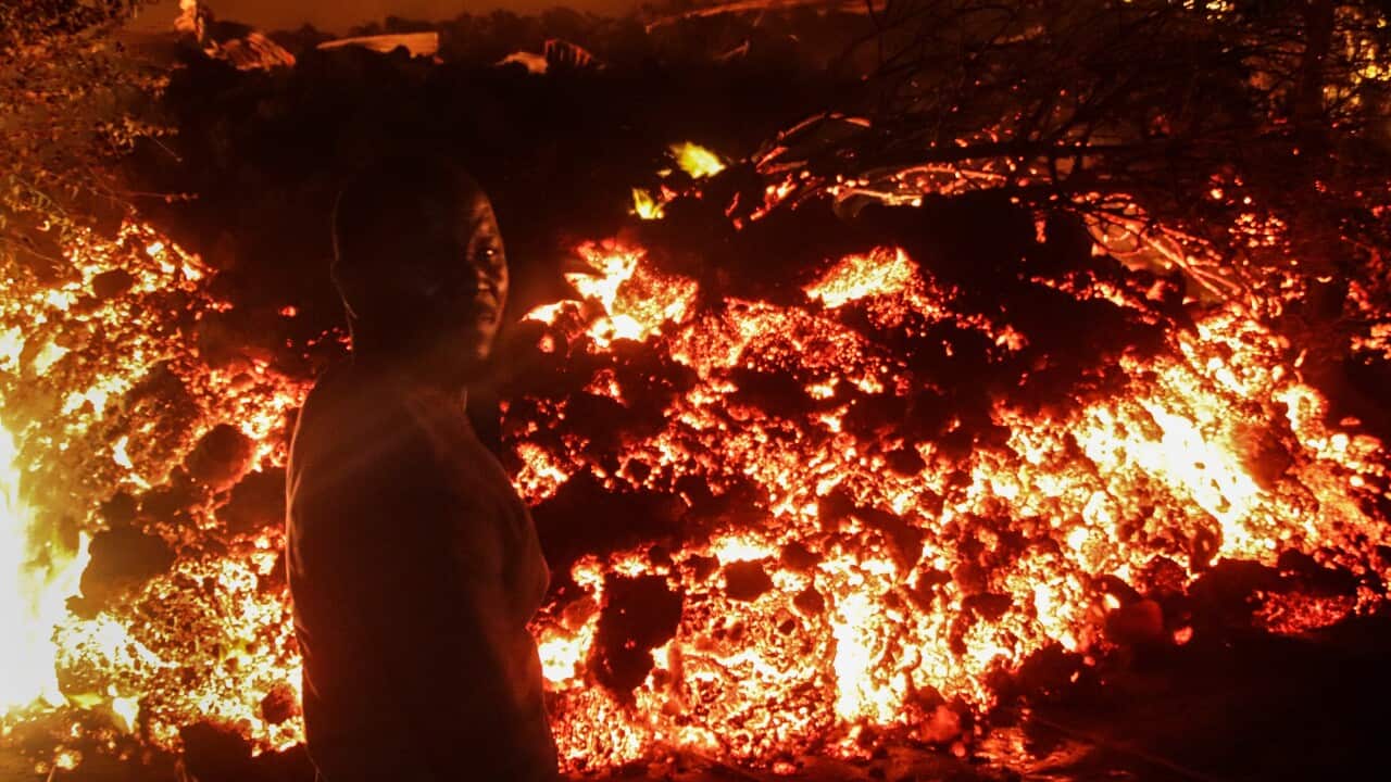 A person stands in front of lava from the eruption of Mount Nyiragongo, in Buhene, on the outskirts of Goma, Congo in the early hours of Sunday, May 23, 2021.