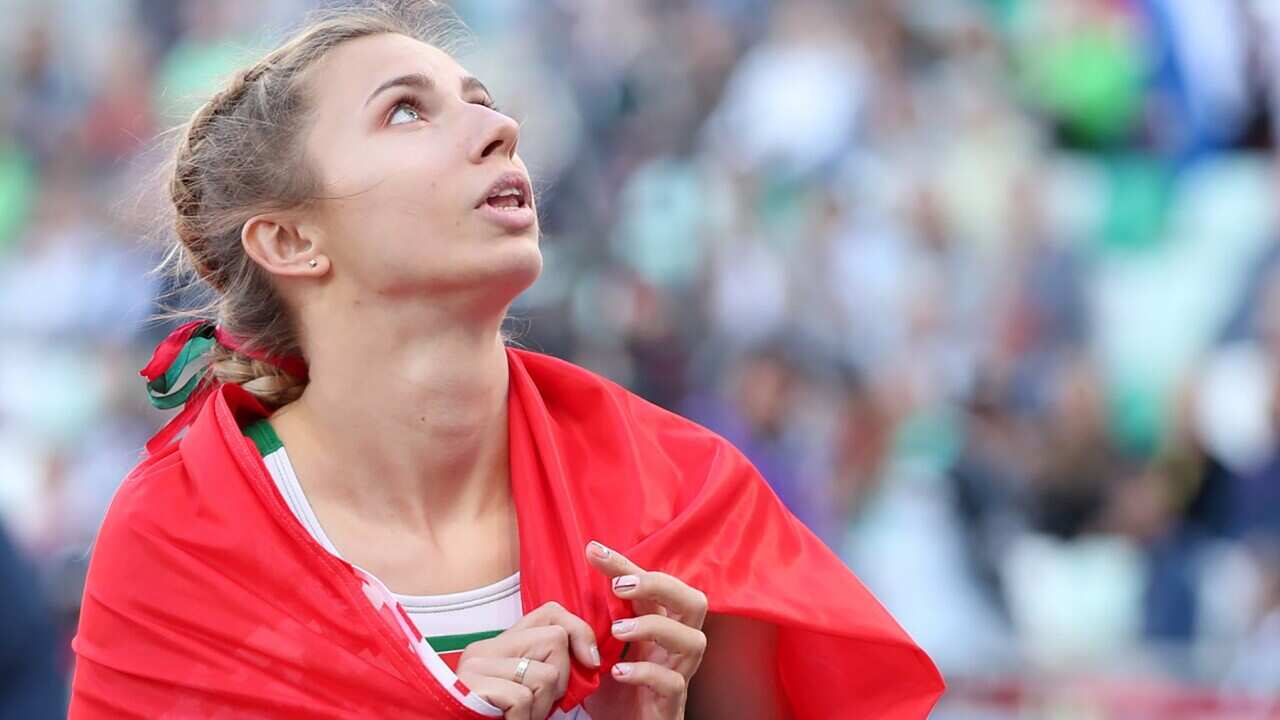 in this file image dated June 28, 2019 is Belarusian sprinter Kristina Timanovskaya wrapped in a Belarusian national flag after winning silver in the track and field team event at the 2019 European Games.