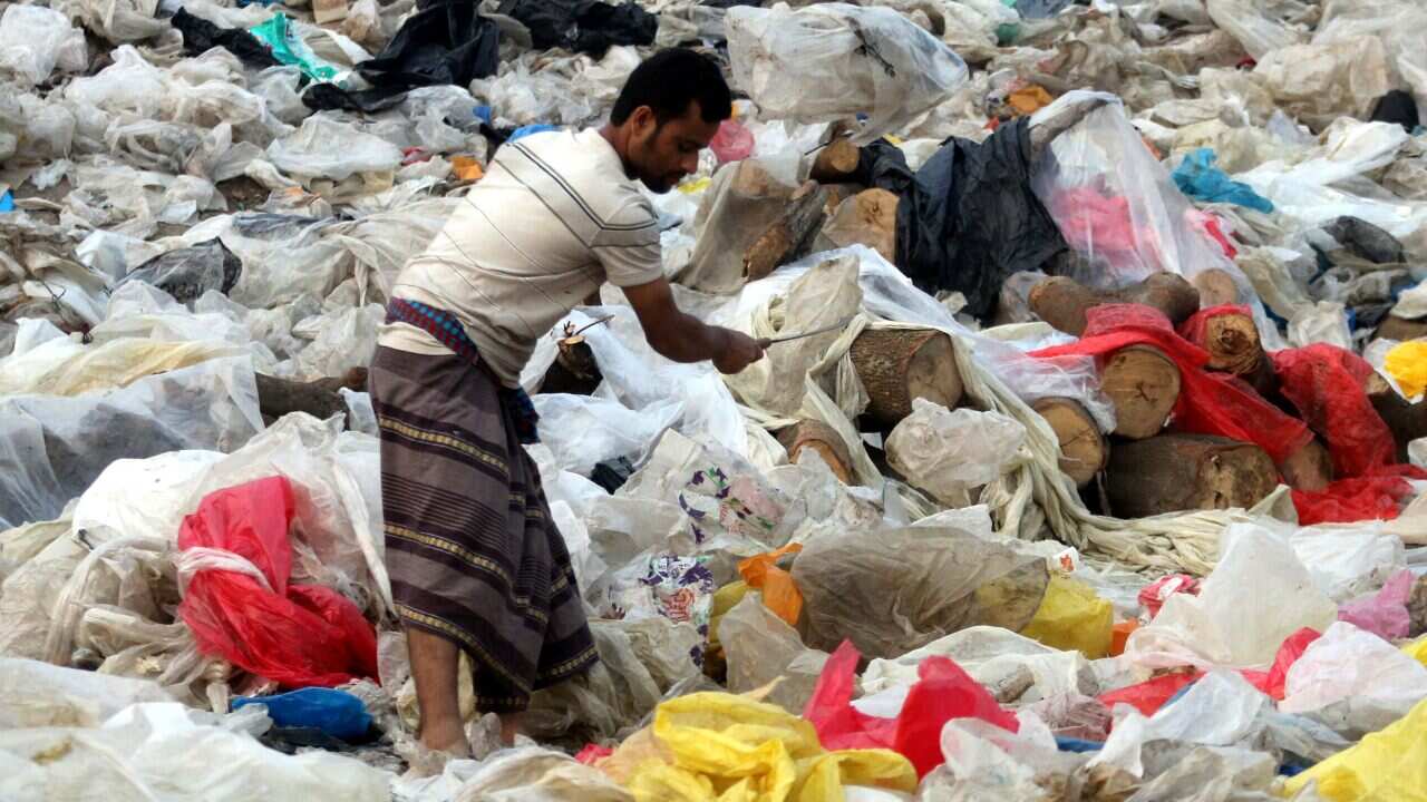 A man is seen checking wasted polythene to be used for making plastic goods after recycling