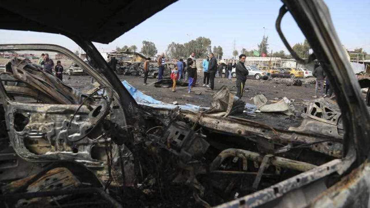 File photo: Civilians inspect the aftermath of a car bomb attack in an auto dealership in the southwestern al-Bayaa neighborhood, Baghdad, Iraq