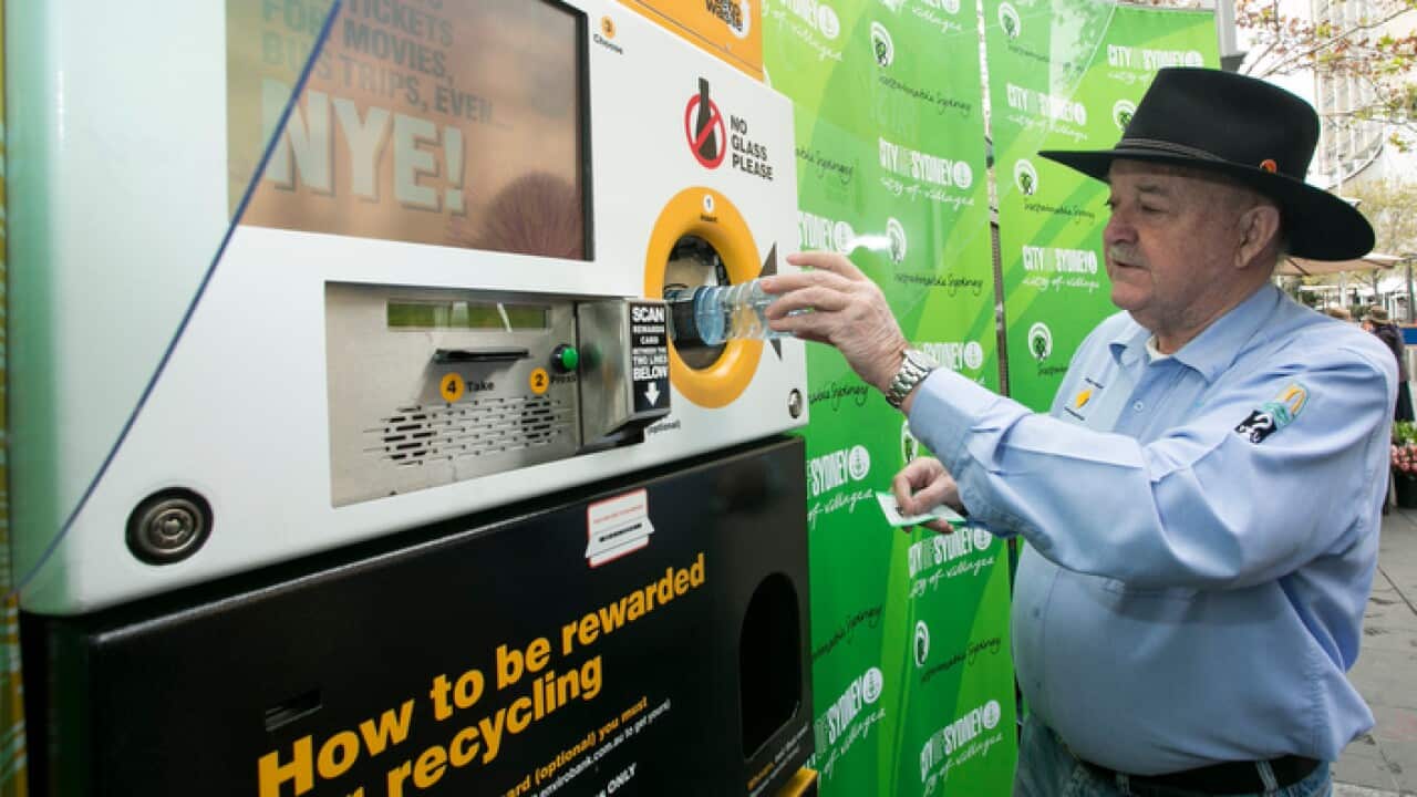 Depositing a plastic bottle into an Envirobank reverse vending recycling machine