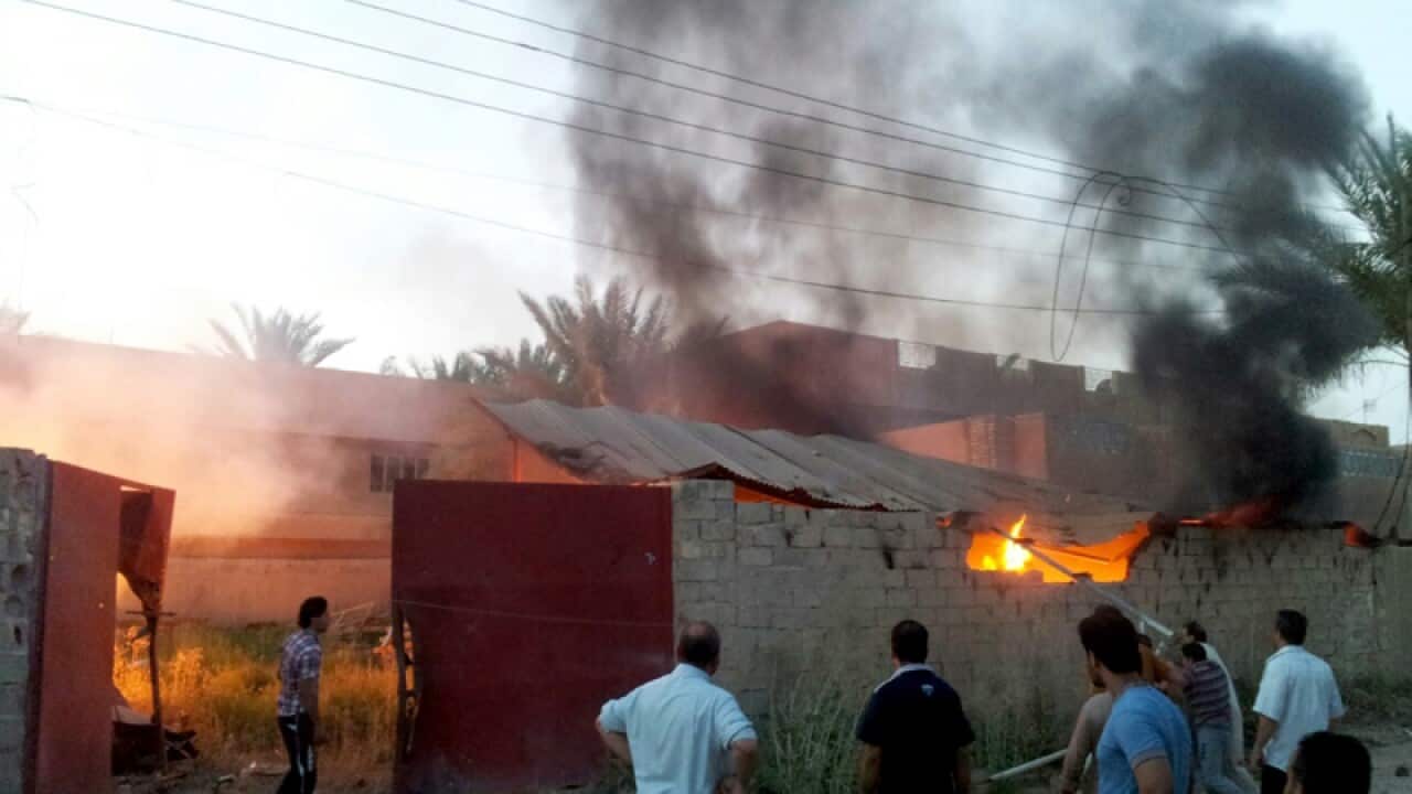 Civilians inspect a burned house