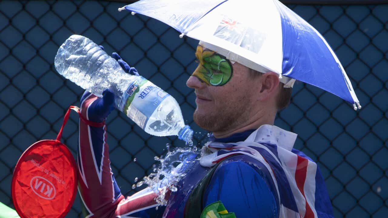 A spectator pours water over himself to beat the heat 