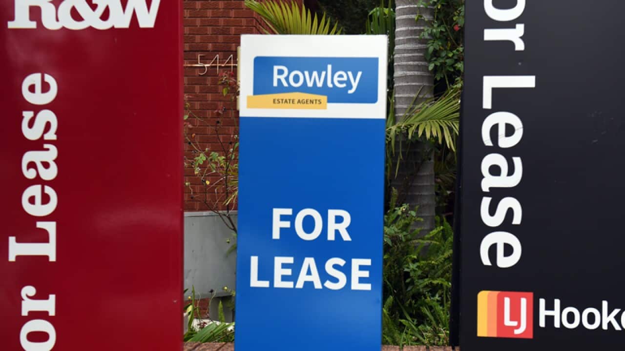 For Lease signs outside a block of apartments
