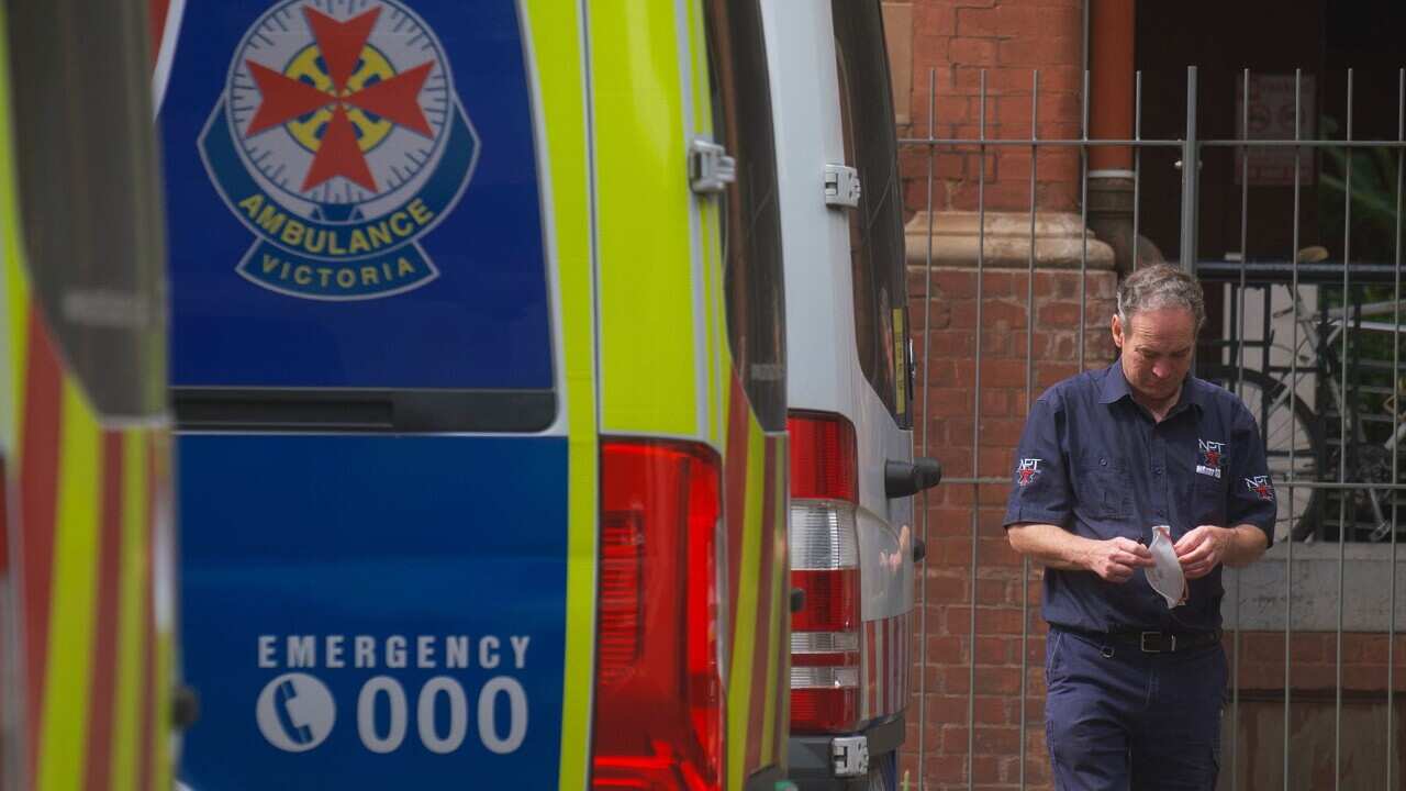 Sağlık görevlileri Melbourne'deki St Vincent hastanesinin dışında ambulanslarıyla ilgileniyorlar