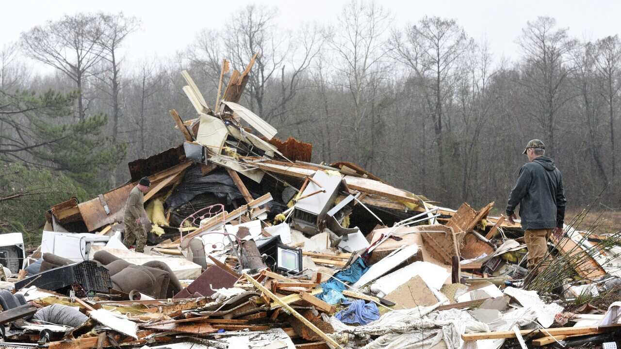 A family member searches through the remains of the home that was destroyed by severe weather in in Benton, Louisiana.