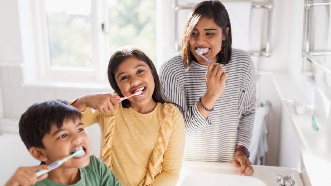 Portrait happy family brushing teeth in bathroom