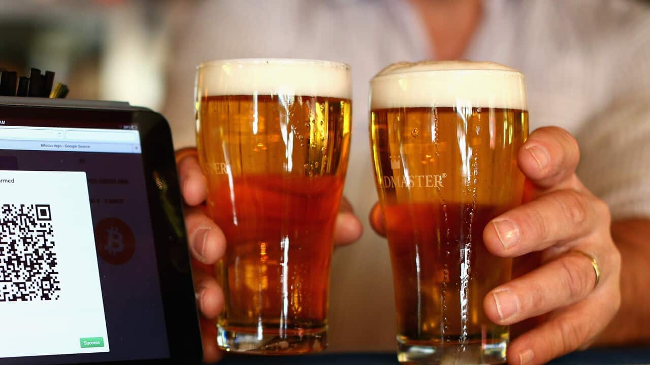 Cups of beer sitting on a bar.