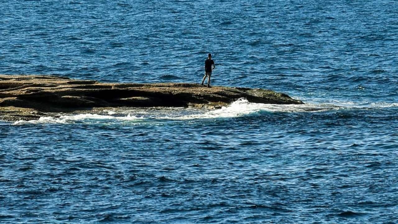 A fisherman is seen fishing at Coogee