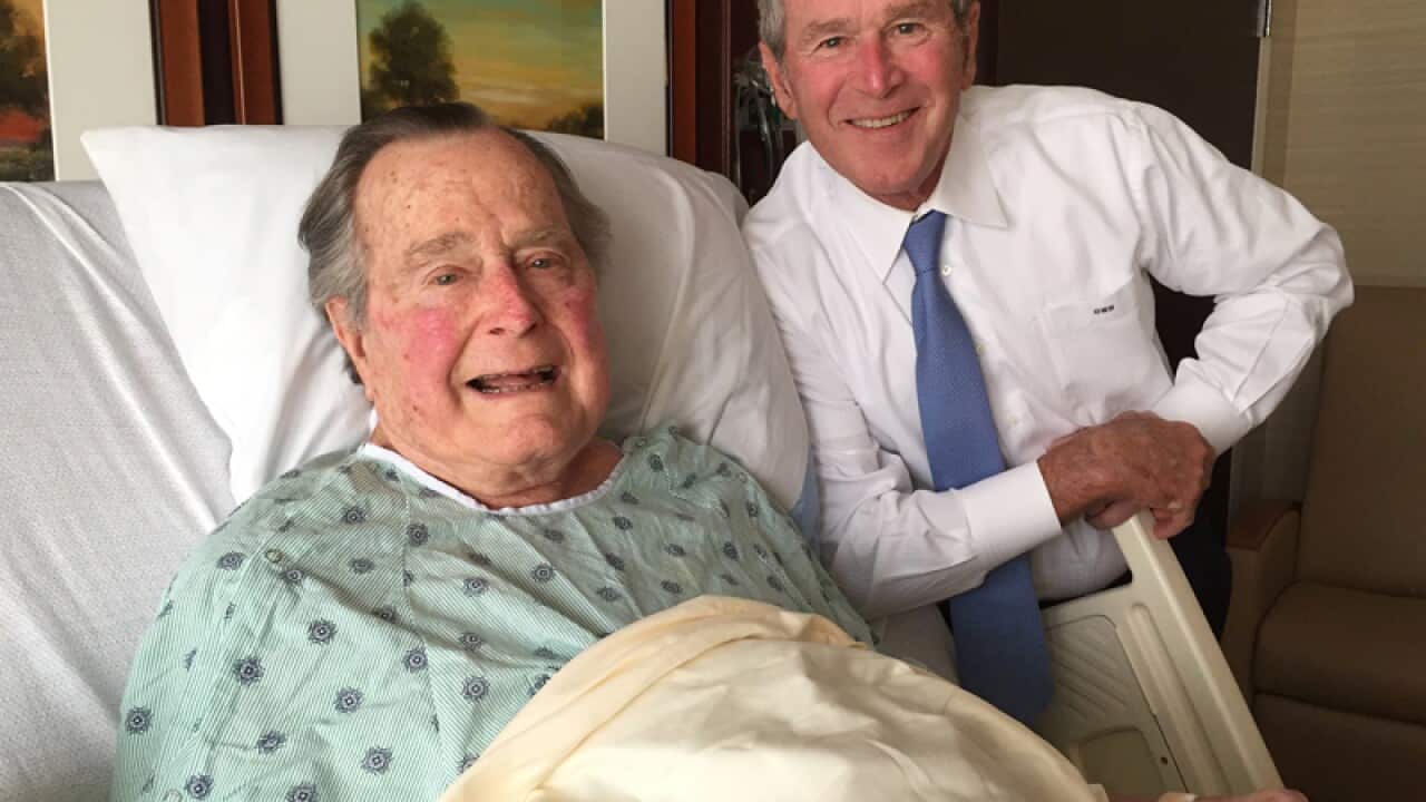 Former President George H.W. Bush, left, posing with his son
