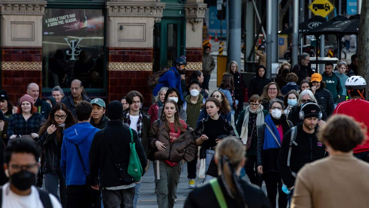 People walk along Flinders Street, Melbourne.