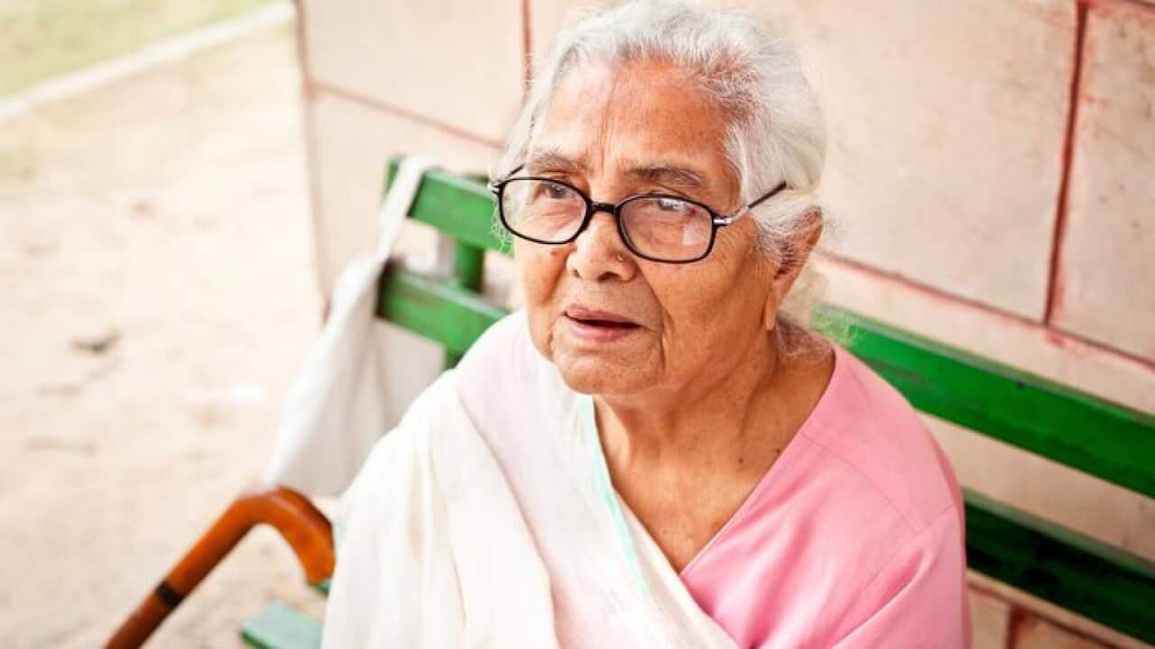 One sad pensive senior Indian woman sitting outdoors
