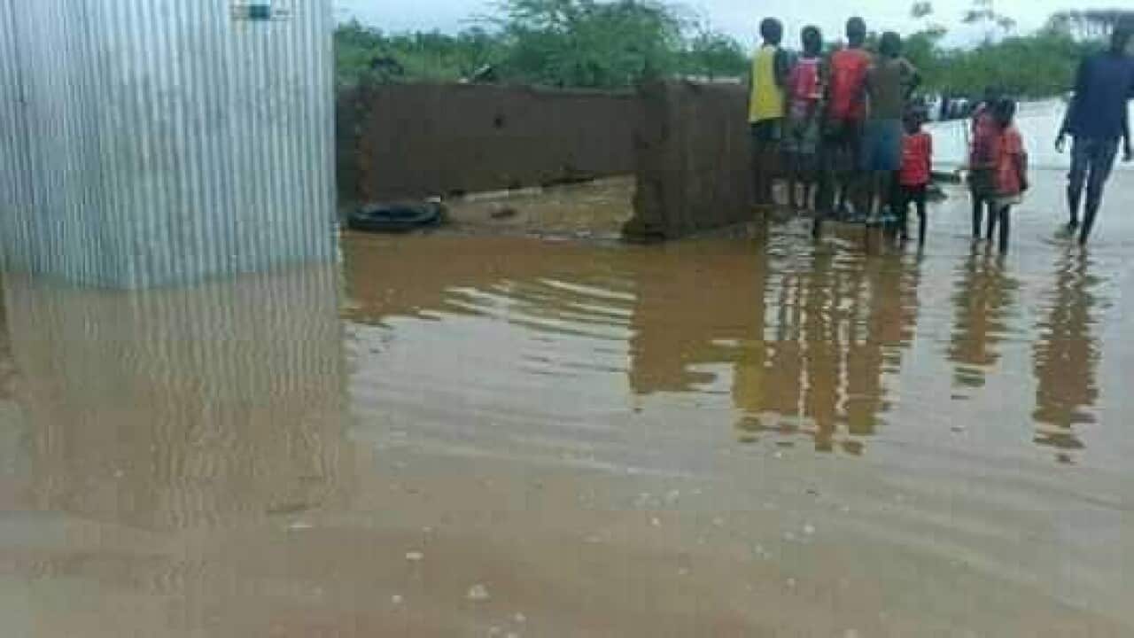 Refugees standing outside after the house collapsed