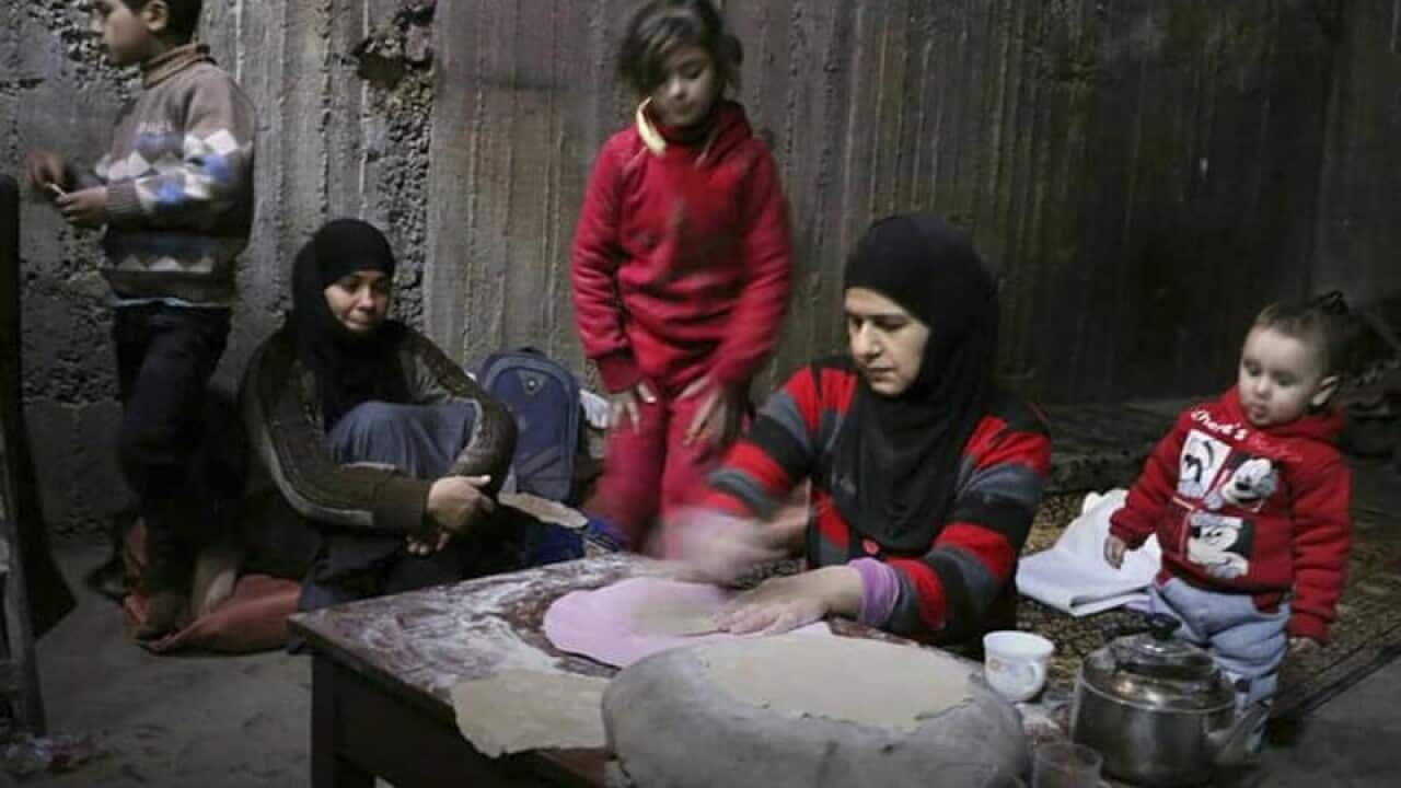 A woman bakes bread in a shelter in eastern Ghouta