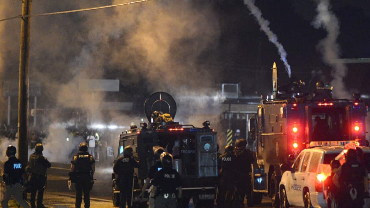 Police fire gas canisters at a crowd of protesters in Ferguson