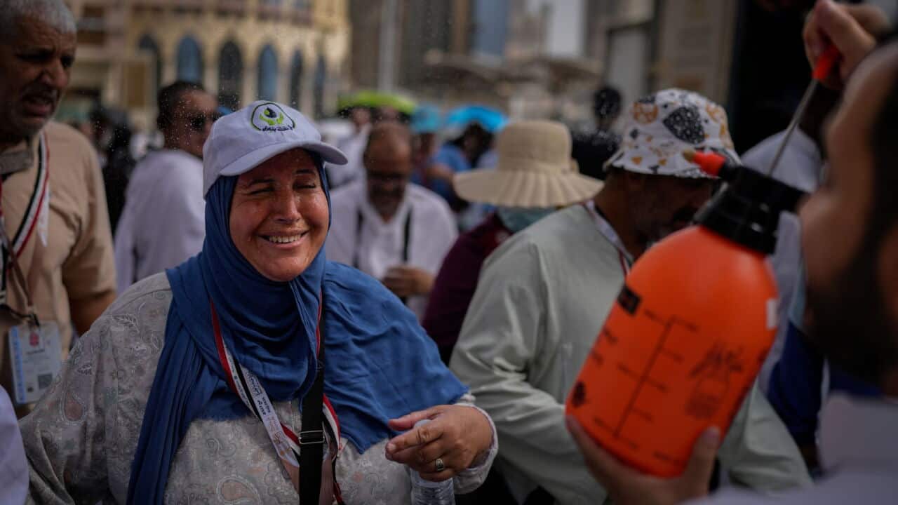 A Muslim pilgrim reacts as a volunteer sprays water to cool them outside the Grand Mosque during the annual hajj pilgrimage at the holy city of Mecca, Saudi Arabia (AP Photo-Altaf Qadri).jpg