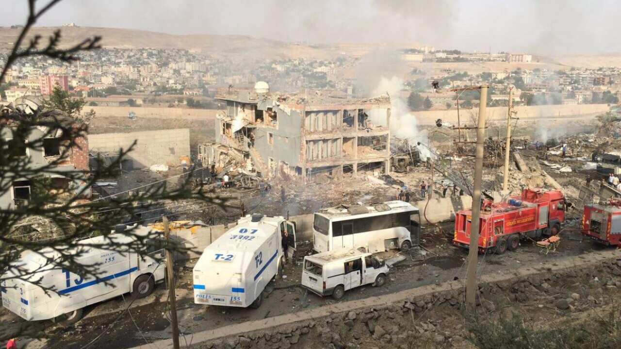 Turkish police and firefighters are parked near a damaged police headquarters after a car bomb which killed scores of people