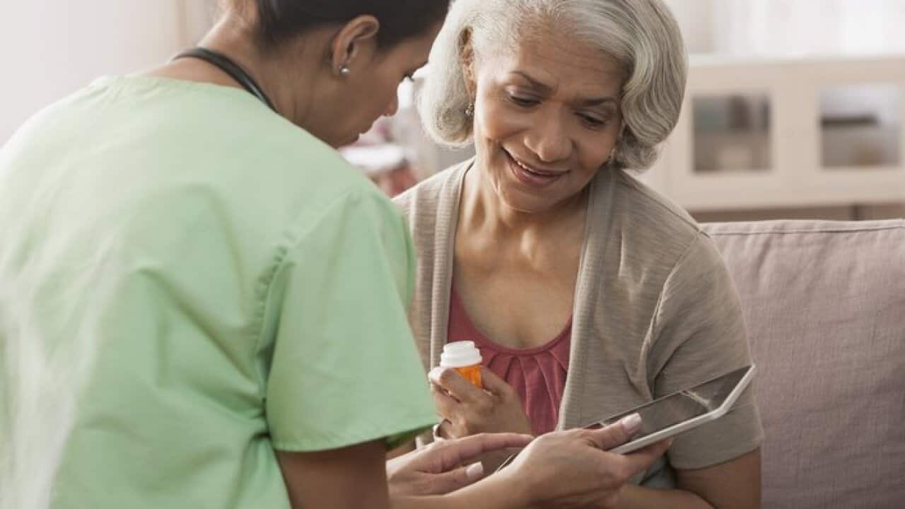 Nurse and older patient using tablet computer