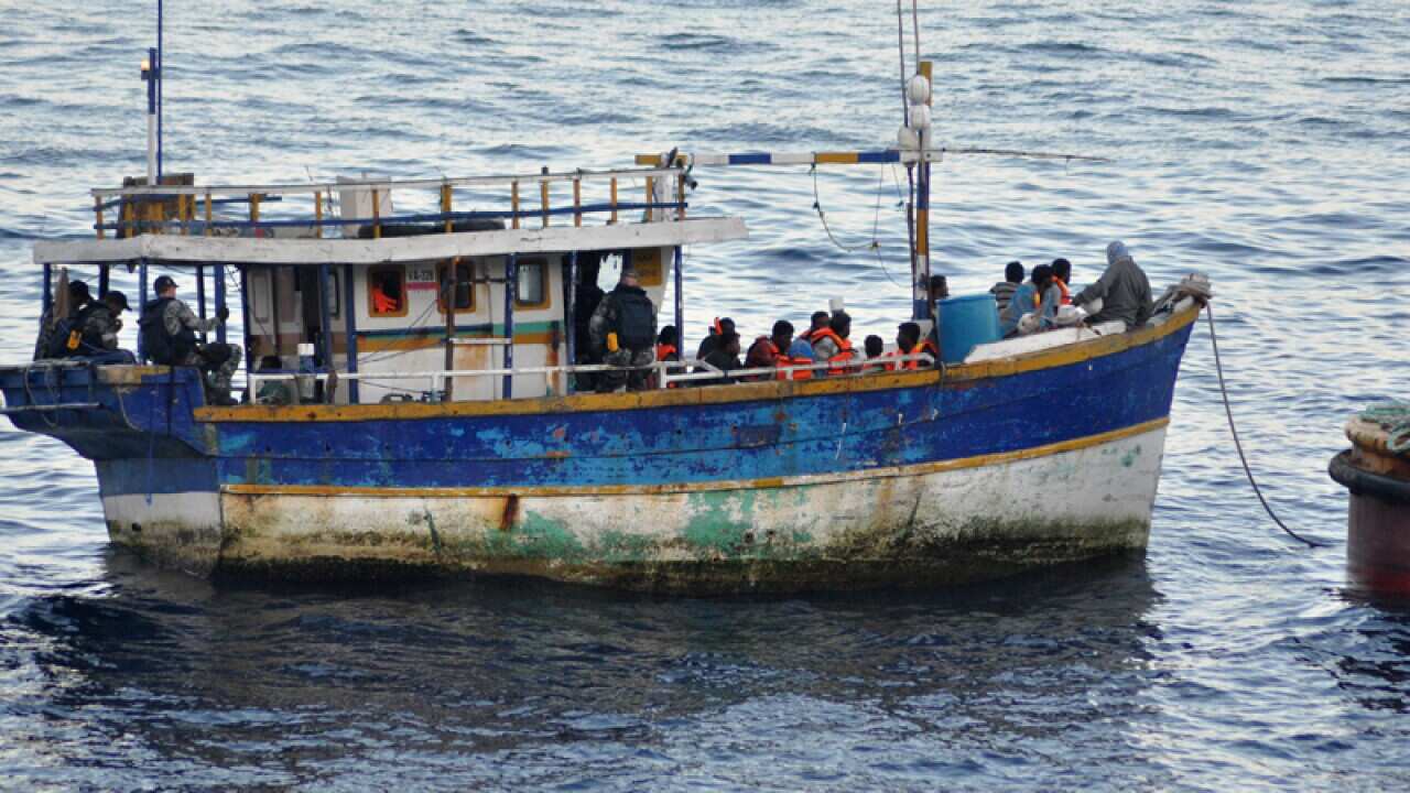 An asylum seeker boat escorted by an Australian navy patrol boat