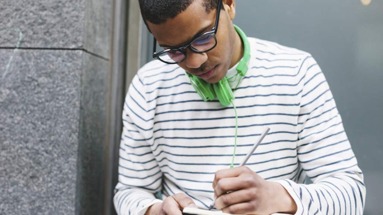 Young man writing in a journal