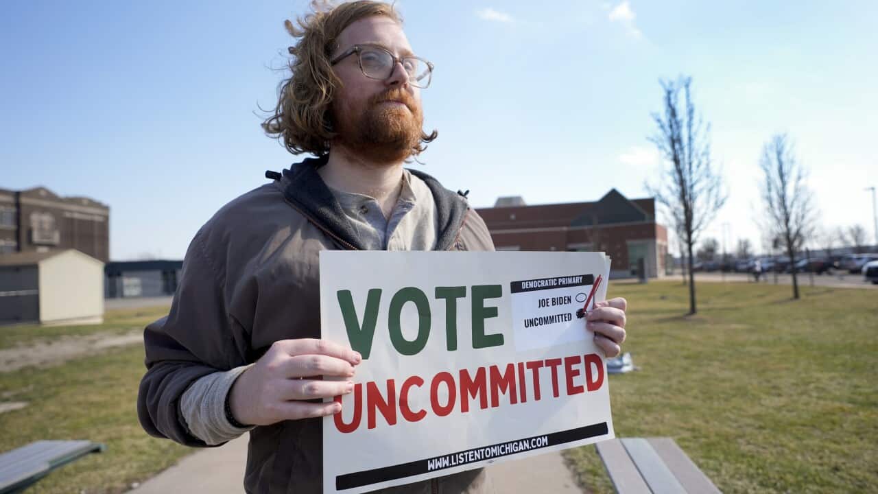 Eric Suter-Bull holds a Vote Uncommitted sign outside a voting location in Dearborn, Mich., Tuesday, Feb. 27, 2024.