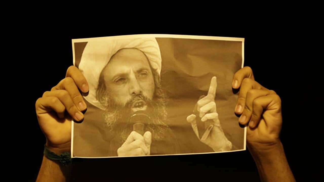 A Bahraini anti-government protester holds a picture of Nimr al-Nimr