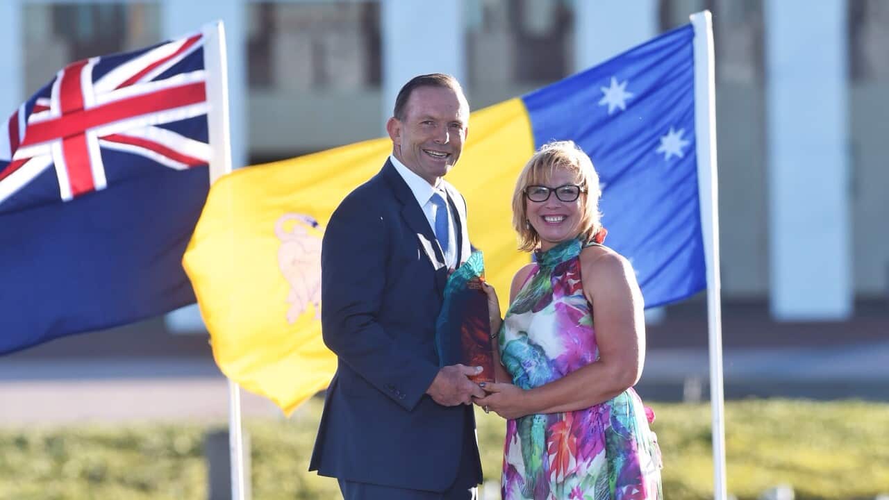 Prime Minister Tony Abbott presents Rosie Batty as 2015 Australian of the Year award at the Australian of the Year Awards at Parliament House lawns in Canberra, Sunday, Jan. 25, 2015. (AAP Image/Wayne King) NO ARCHIVING