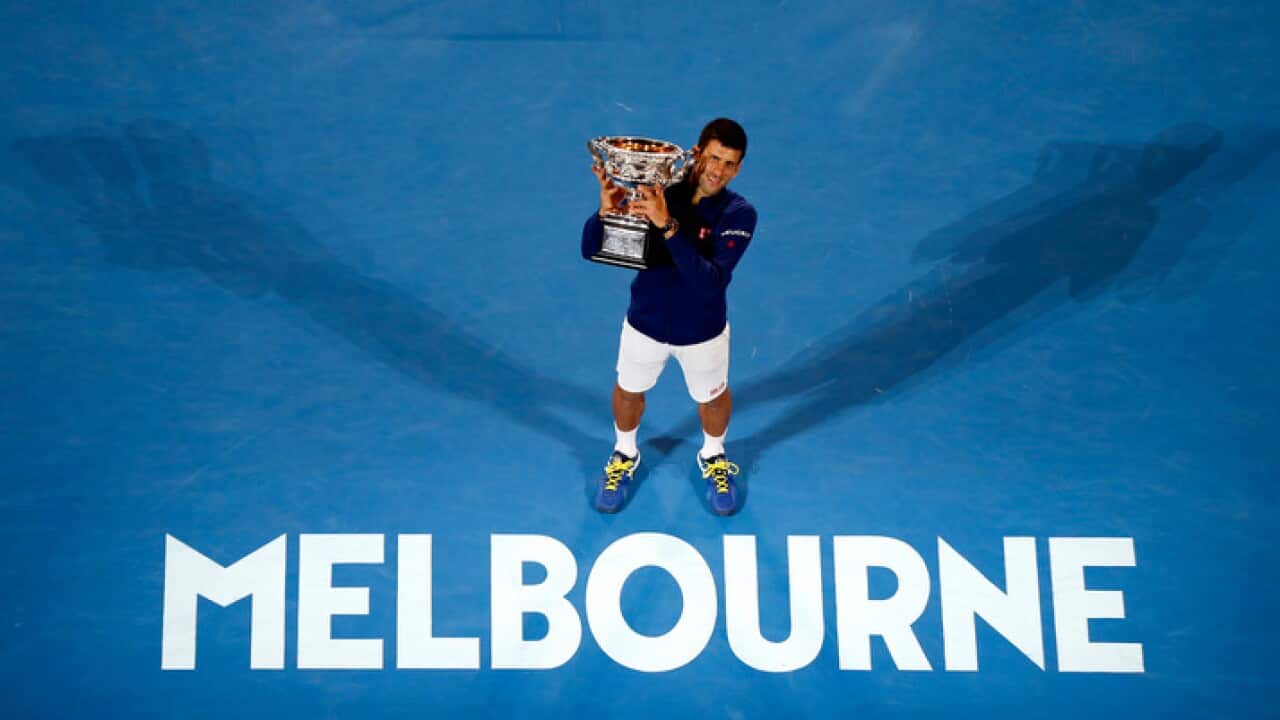 Novak Djokovic of Serbia holds his trophy aloft after defeating Andy Murray of Britain in the men's singles final at the Australian Open tennis championships in Melbourne, Australia, Sunday, Jan. 31, 2016.(AP Photo/Vincent Thian)
