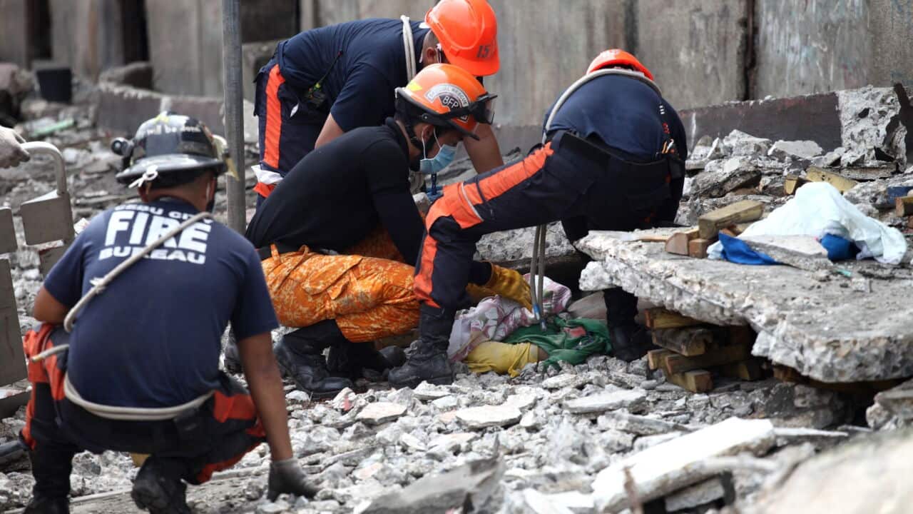 Rescuers try to release a victim from under slabs of cement in Cebu City - AAP.jpg