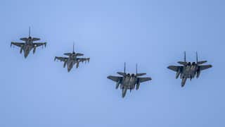 Four fighter jets flying in a V formation.