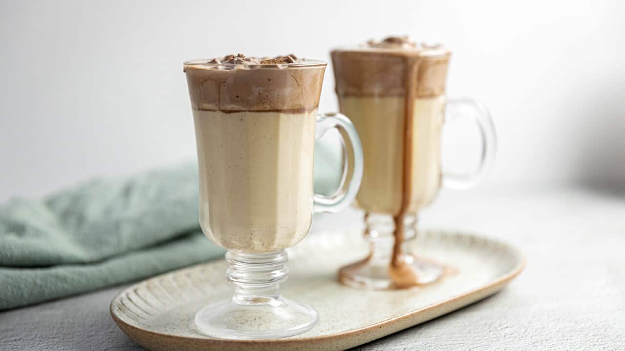 Two glasses hold a creamy drink with a chocolate-coloured layer at the top.
