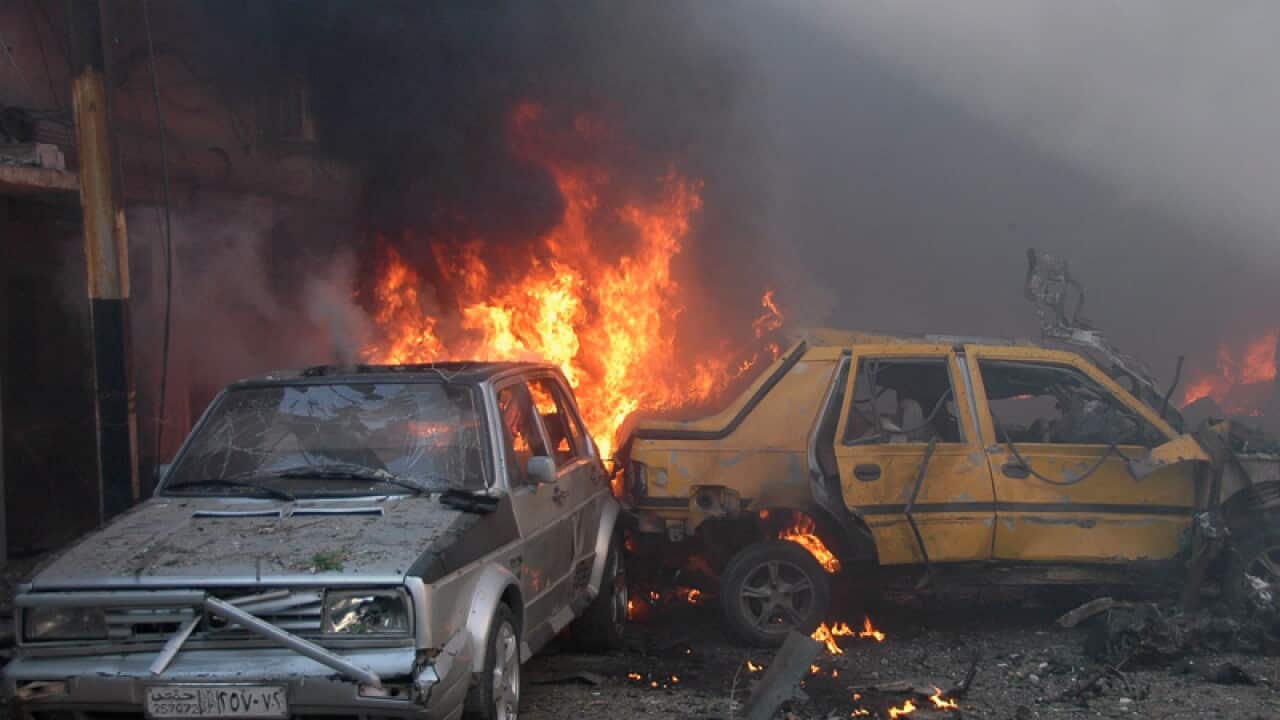 Vehicles burning after a car bomb explosion in Homs