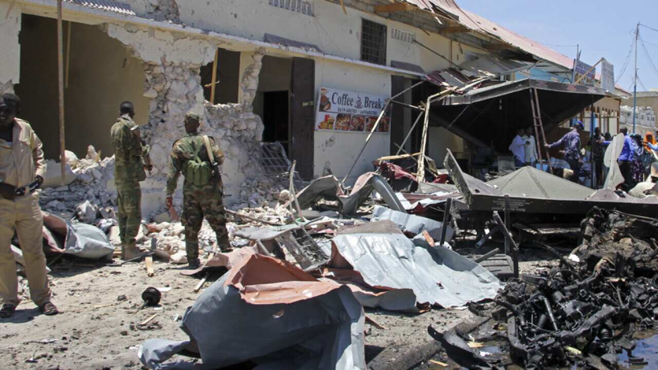Somali security forces attend the scene of a car bomb attack